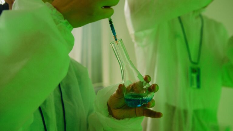 Photo by Artem Podrez Close-up of a scientist using a syringe to handle chemicals in a laboratory setting.